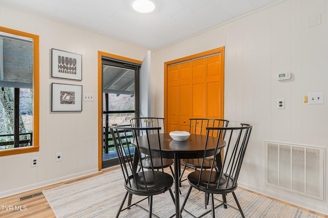 dining area featuring light hardwood / wood-style floors and ornamental molding