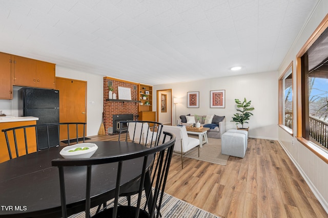 dining area with built in shelves and light wood-type flooring