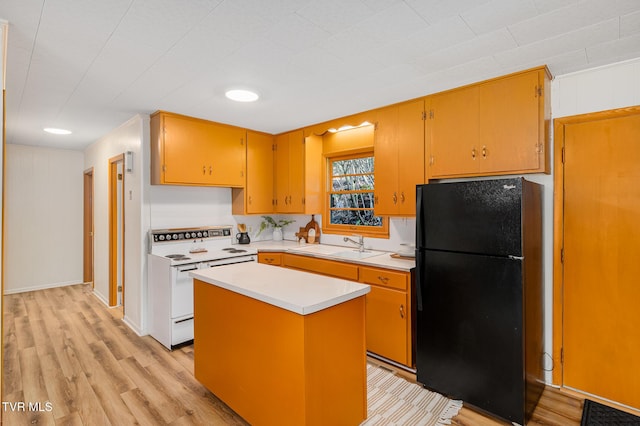 kitchen featuring a center island, sink, black fridge, light hardwood / wood-style floors, and electric stove