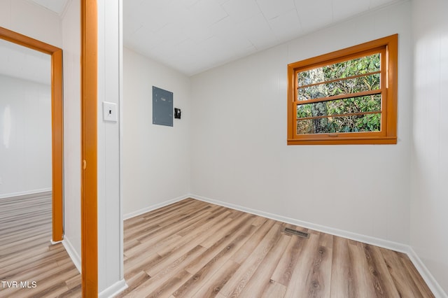 spare room with light wood-type flooring and electric panel