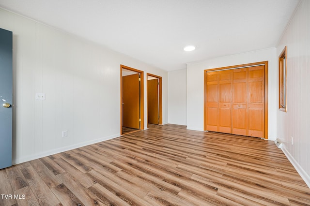 unfurnished bedroom featuring light hardwood / wood-style flooring and a closet