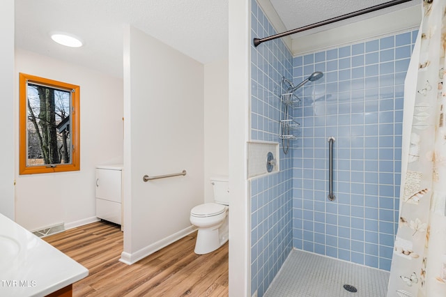 bathroom featuring vanity, wood-type flooring, washer / clothes dryer, toilet, and curtained shower