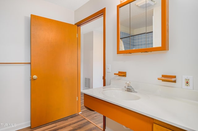 bathroom featuring wood-type flooring, a textured ceiling, and sink