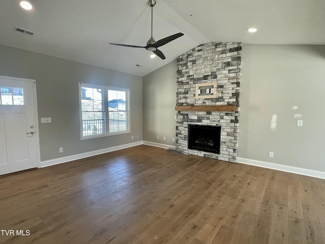 unfurnished living room with ceiling fan, a stone fireplace, lofted ceiling, and hardwood / wood-style flooring