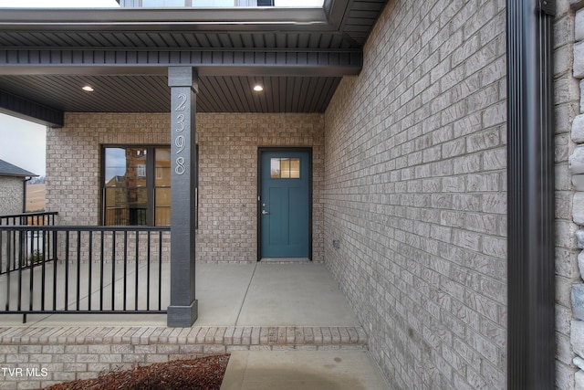 view of exterior entry featuring covered porch