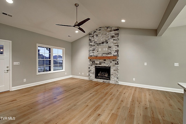 unfurnished living room with a stone fireplace, light hardwood / wood-style flooring, ceiling fan, and vaulted ceiling