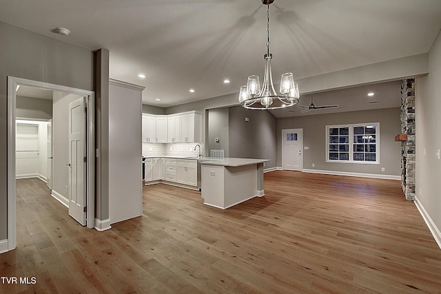 kitchen with white cabinetry, pendant lighting, tasteful backsplash, and light wood-type flooring