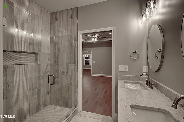 bathroom with ceiling fan, vanity, and a shower with door