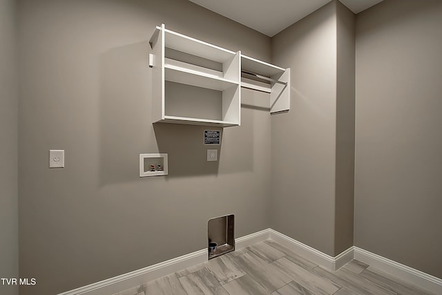 clothes washing area featuring hookup for a washing machine, hookup for an electric dryer, and light wood-type flooring