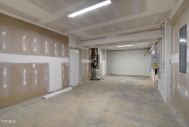 basement featuring electric panel and tankless water heater