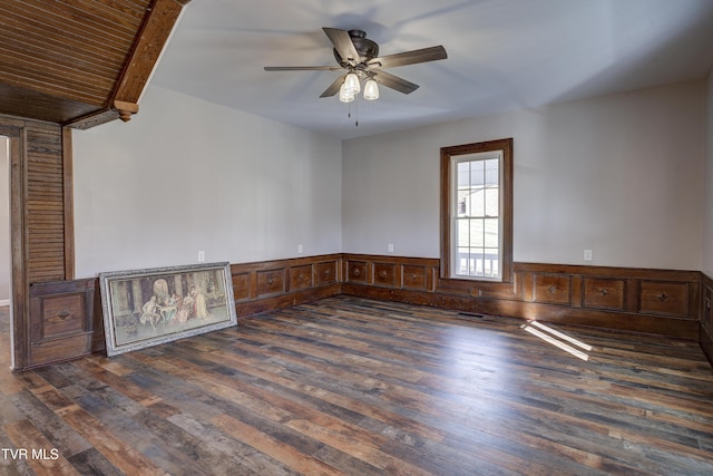 unfurnished room with beamed ceiling, dark hardwood / wood-style floors, ceiling fan, and wood ceiling