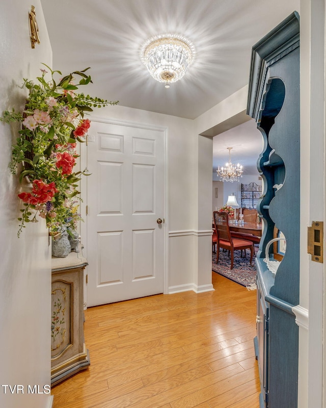 entrance foyer with a notable chandelier and light wood-type flooring