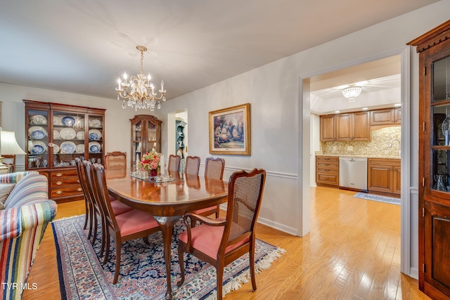 dining space featuring light hardwood / wood-style floors and a notable chandelier