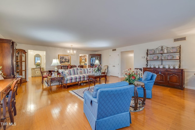 living room with a notable chandelier and light hardwood / wood-style floors