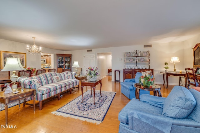 living room with light hardwood / wood-style flooring and an inviting chandelier