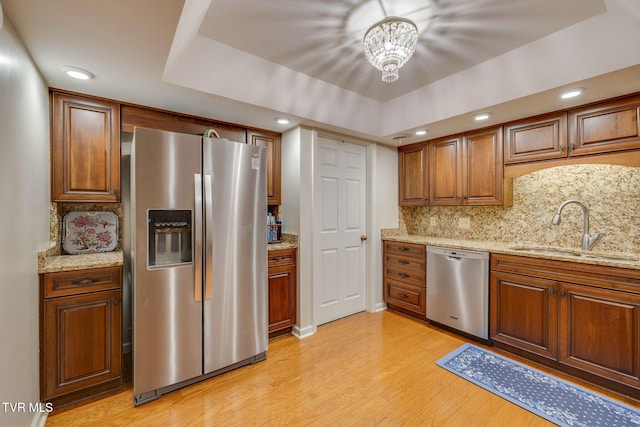 kitchen with light stone countertops, sink, appliances with stainless steel finishes, and tasteful backsplash