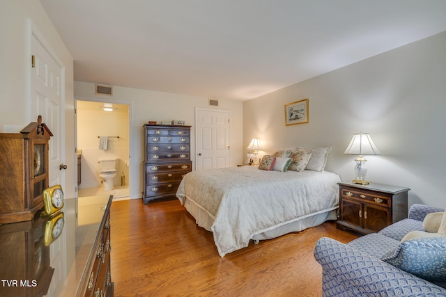 bedroom featuring ensuite bathroom and wood-type flooring