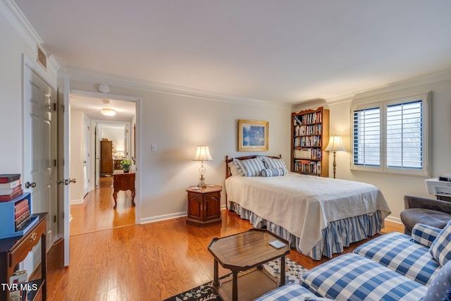 bedroom with light hardwood / wood-style floors and crown molding