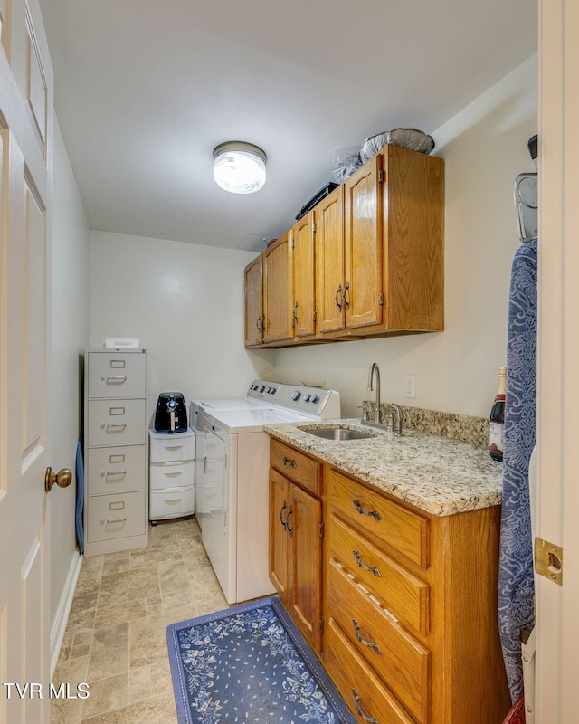 clothes washing area with cabinets, sink, and washing machine and clothes dryer