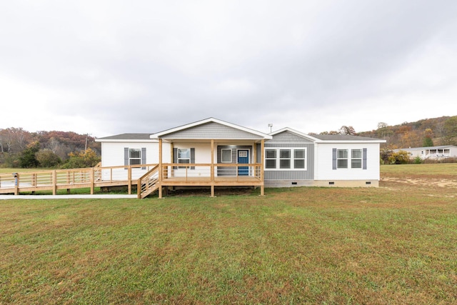 back of property featuring a wooden deck and a yard