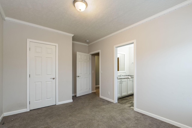 unfurnished bedroom featuring dark colored carpet, sink, crown molding, a textured ceiling, and connected bathroom