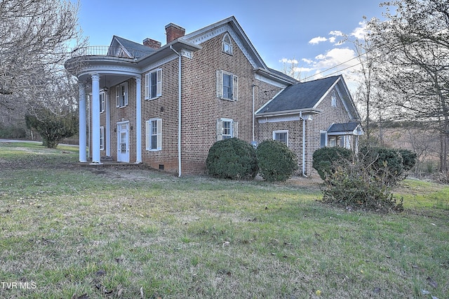 view of side of home featuring a balcony and a yard