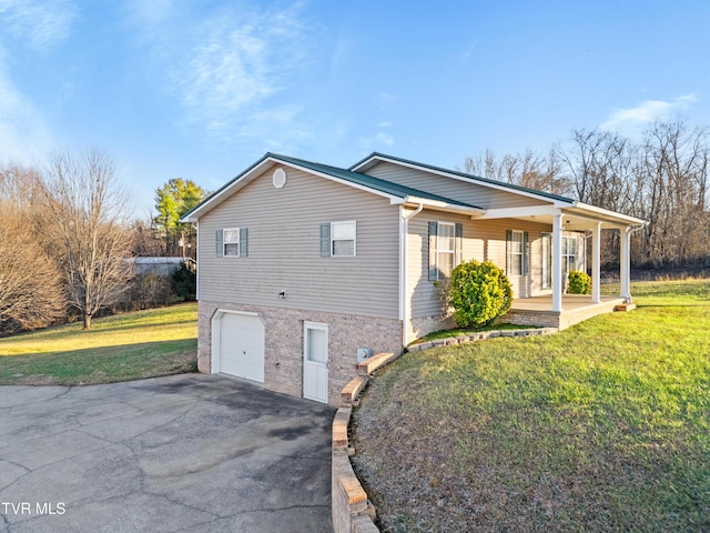 view of side of property featuring a garage, covered porch, and a yard