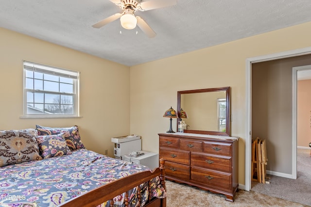 carpeted bedroom featuring ceiling fan and a textured ceiling