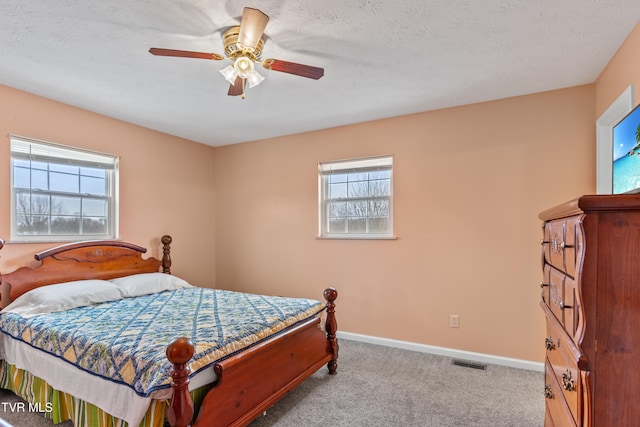 carpeted bedroom with multiple windows and ceiling fan