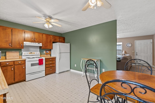 kitchen with a textured ceiling, white appliances, and ceiling fan