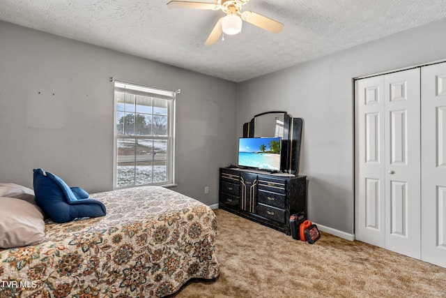 bedroom with carpet, ceiling fan, a textured ceiling, and a closet