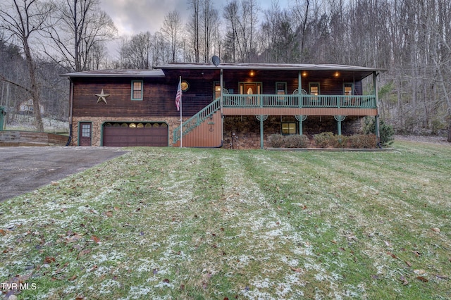 view of front of property with a porch, a front yard, and a garage