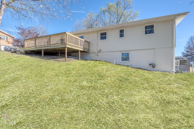 back of house featuring a lawn and a deck