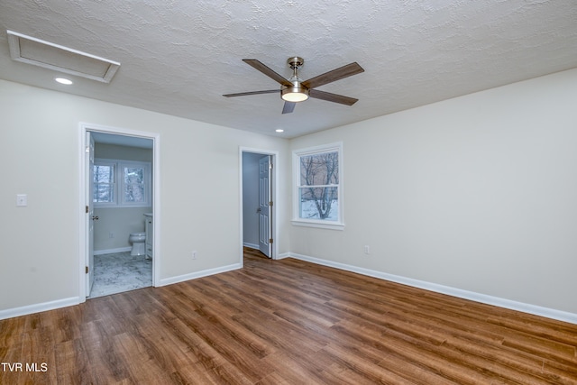 unfurnished bedroom featuring hardwood / wood-style flooring, ceiling fan, a textured ceiling, and ensuite bath