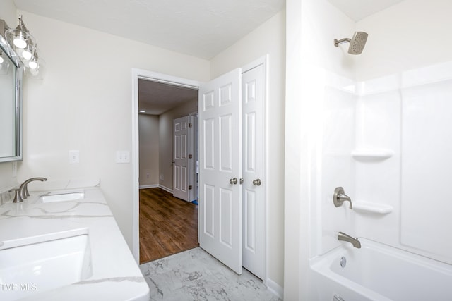 bathroom with wood-type flooring, vanity, and  shower combination