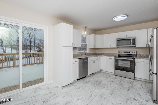 kitchen featuring white cabinetry, sink, light stone counters, and appliances with stainless steel finishes