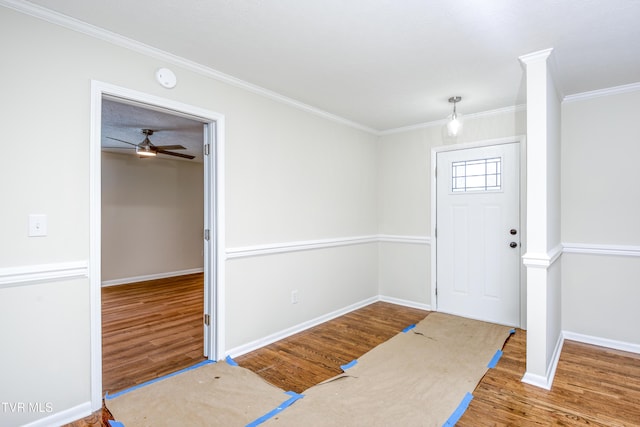 foyer entrance with ceiling fan, wood-type flooring, and crown molding