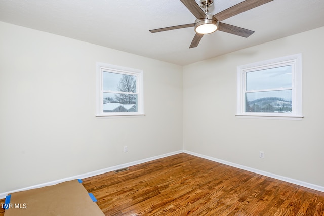 empty room with ceiling fan and hardwood / wood-style flooring