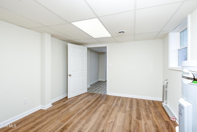 basement featuring light hardwood / wood-style floors and a drop ceiling