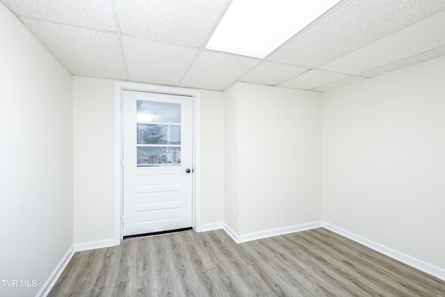 unfurnished room with a paneled ceiling and light hardwood / wood-style floors