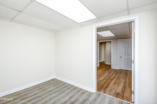 unfurnished room featuring a paneled ceiling and light hardwood / wood-style flooring