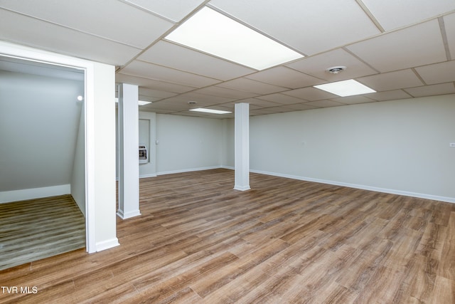 basement with a drop ceiling and hardwood / wood-style flooring