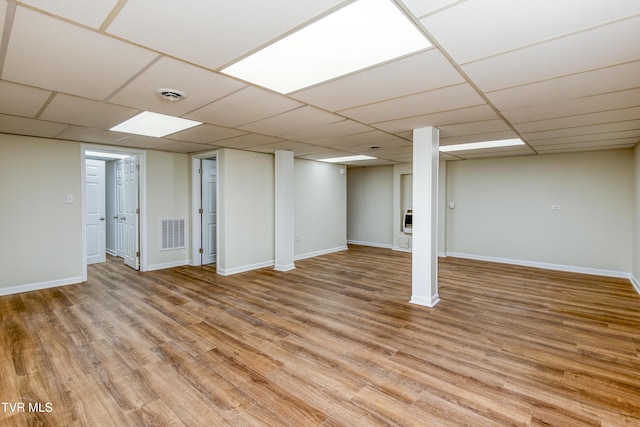 basement with a drop ceiling and light wood-type flooring