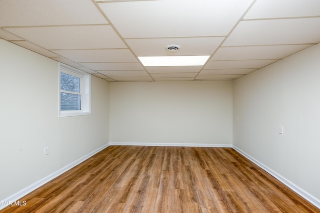 empty room featuring a paneled ceiling and hardwood / wood-style floors