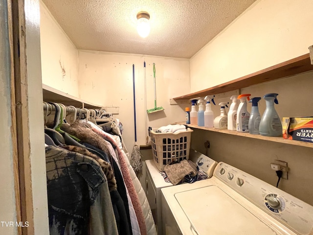 laundry area featuring a textured ceiling and washing machine and clothes dryer