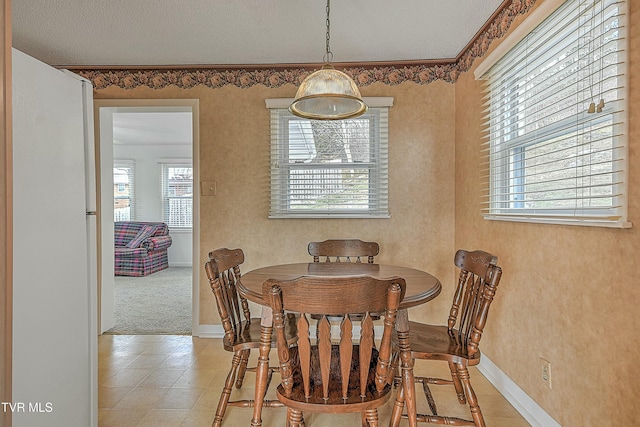 carpeted dining area with a textured ceiling