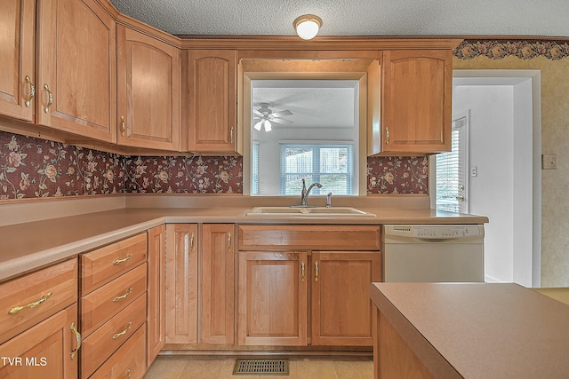 kitchen with a textured ceiling, white dishwasher, ceiling fan, sink, and light tile patterned flooring