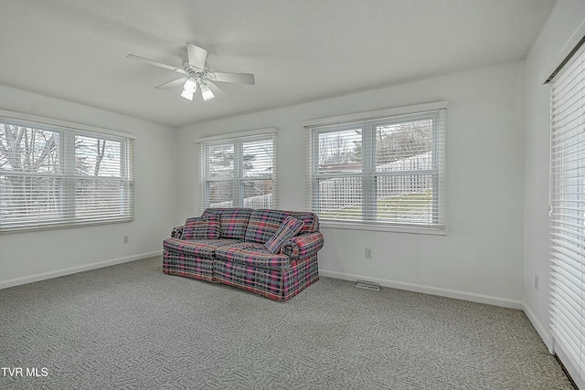 sitting room featuring carpet flooring, ceiling fan, and a textured ceiling