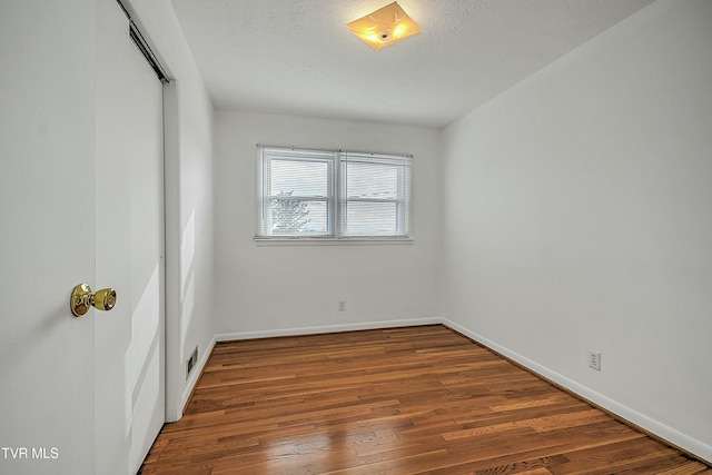 unfurnished room with hardwood / wood-style floors