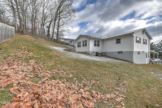 view of home's exterior featuring cooling unit and a lawn